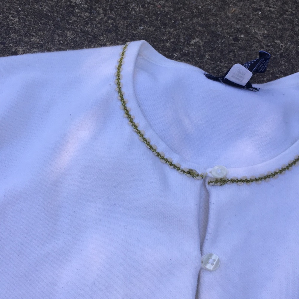White sweater with green trim around neckline - Picture 2 of 3